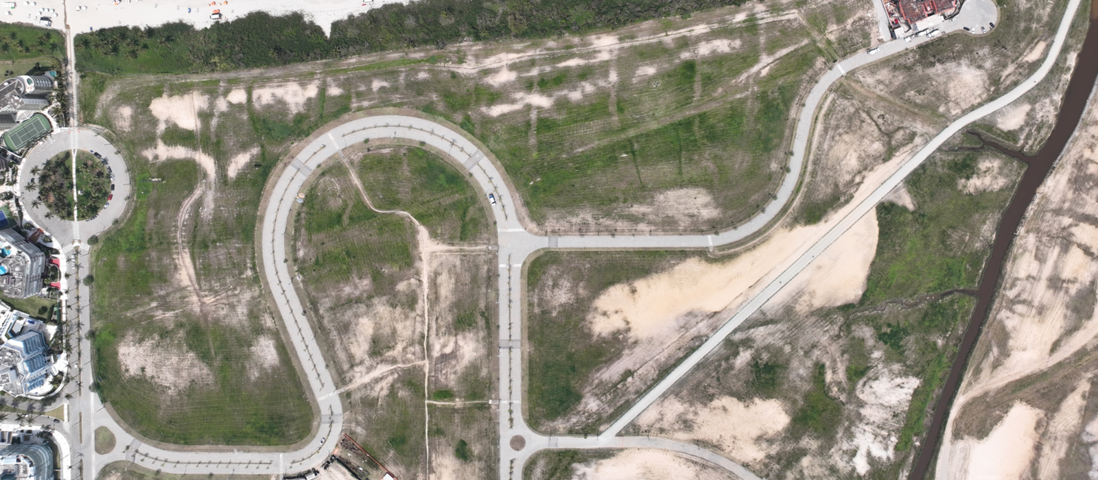 Vista aérea do Módulo 01 — Fragatas, com as vias implantadas e os lotes em fase de ocupação, junto à Praia de São Lourenço